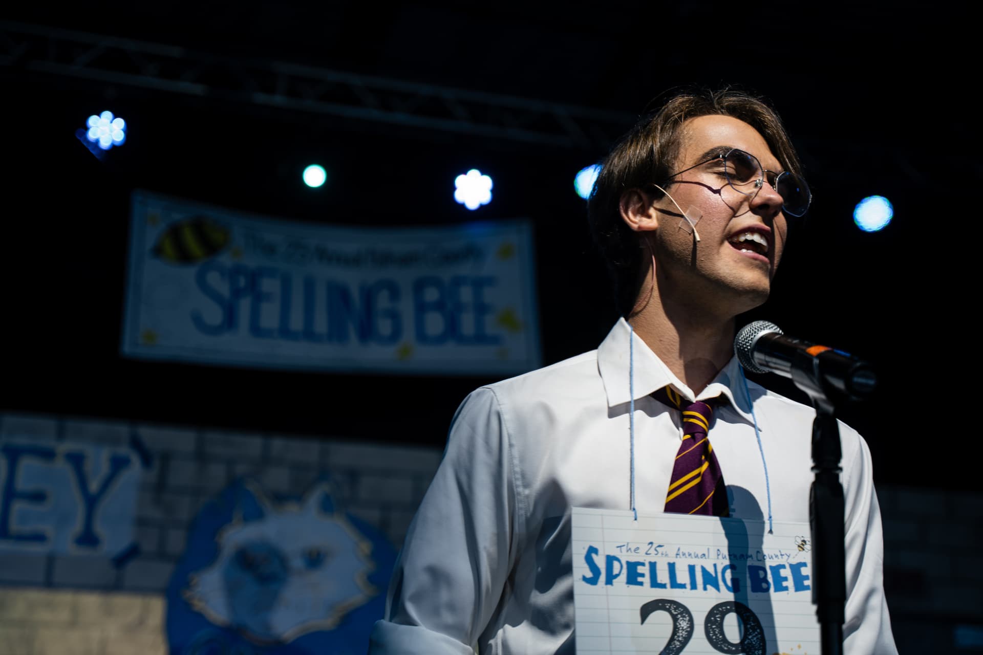 Richard Jordan singing with eyes closed at the microphone during Putnam County Spelling Bee