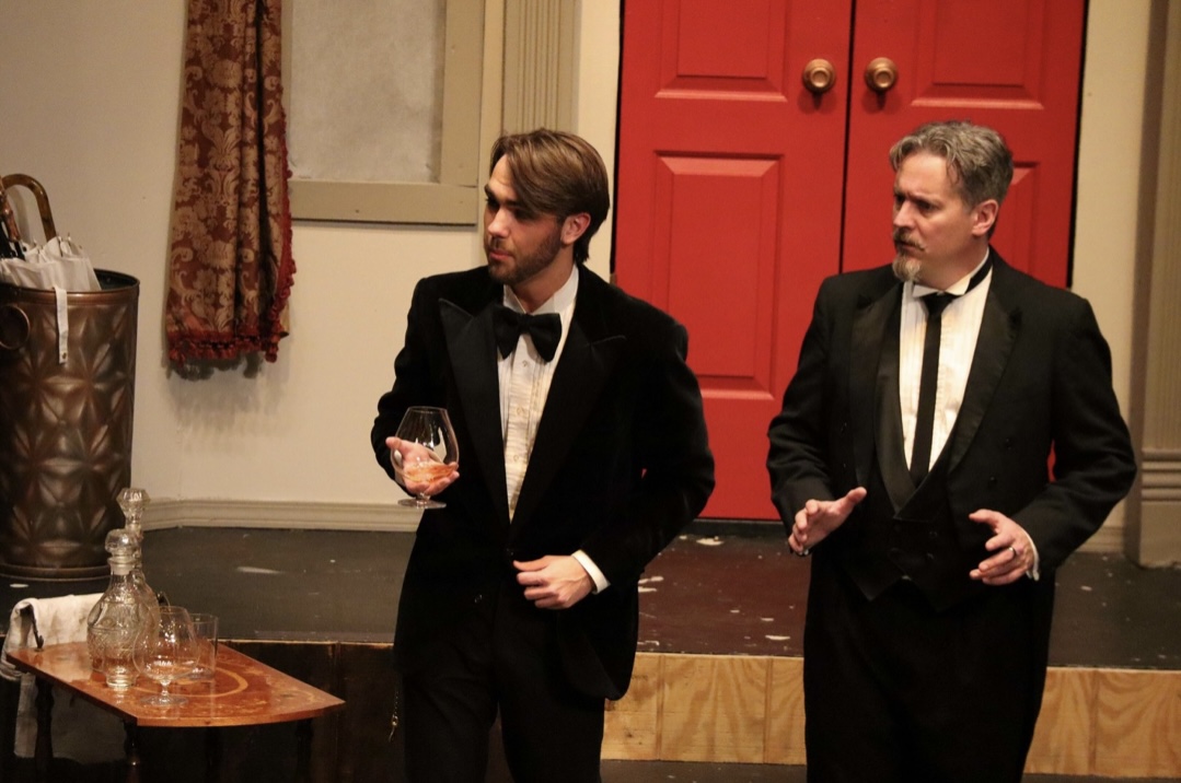 Richard Jordan in a tuxedo with a brandy glass beside another actor in CLUE