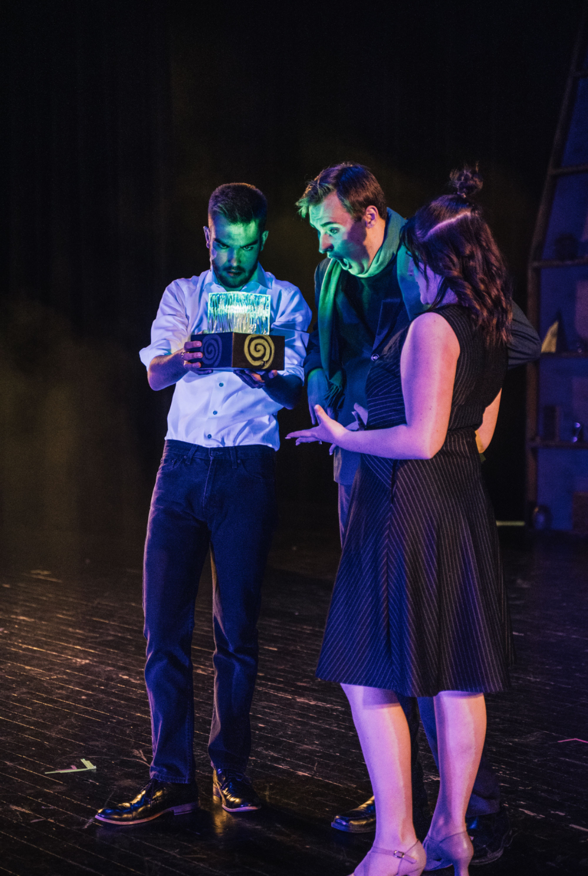 Richard Jordan holding a glowing box in a green-lit stage scene