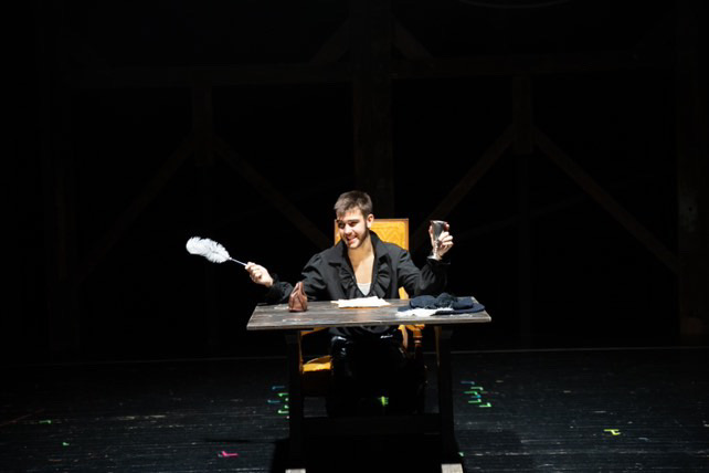 Richard Jordan smiling at a table in a comedic stage moment