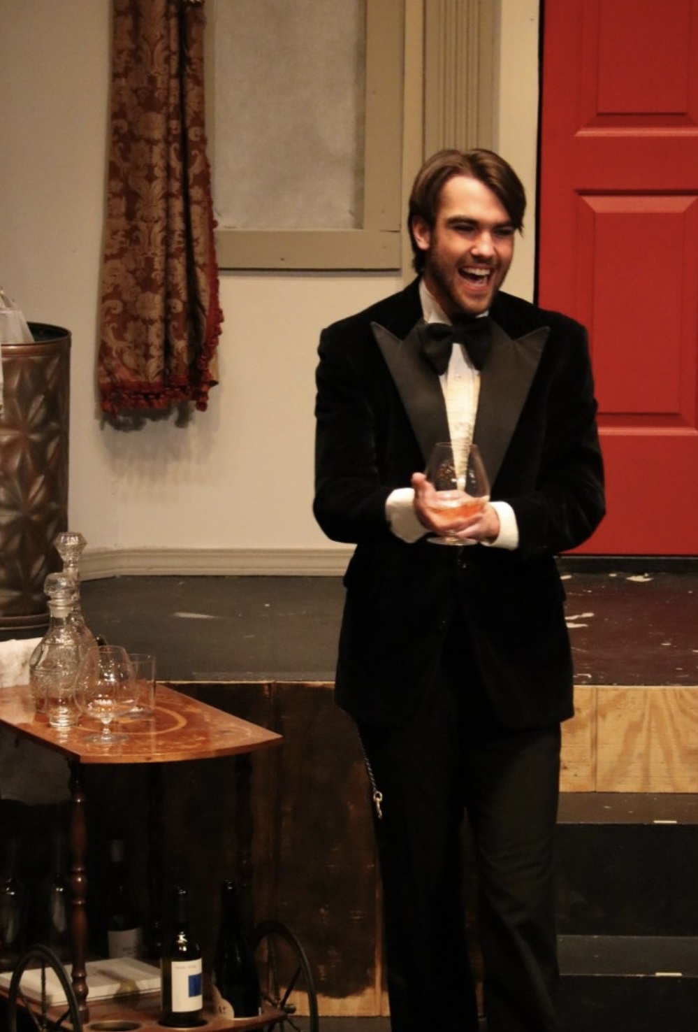Richard Jordan laughing with a glass in hand in CLUE