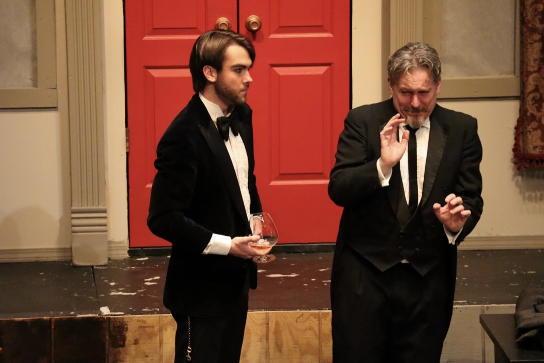 Richard Jordan holding a glass in a tense CLUE scene by the red doors